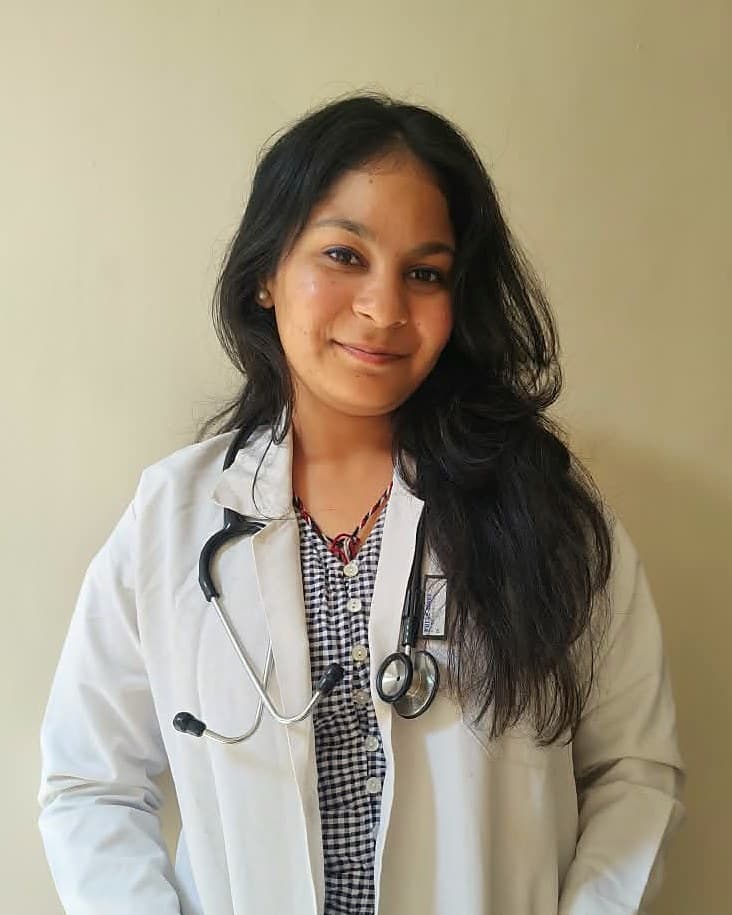 Dr. Diksha, physiotherapist, smiling in a white coat with a stethoscope